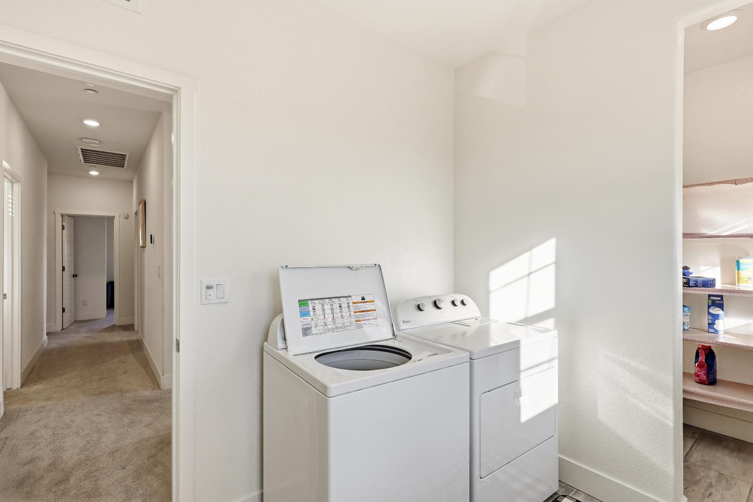 2367 Explorador Drive Merced, CA 95340 - Photo 31 of 42 a view of washer and dryer with kitchen in the background
