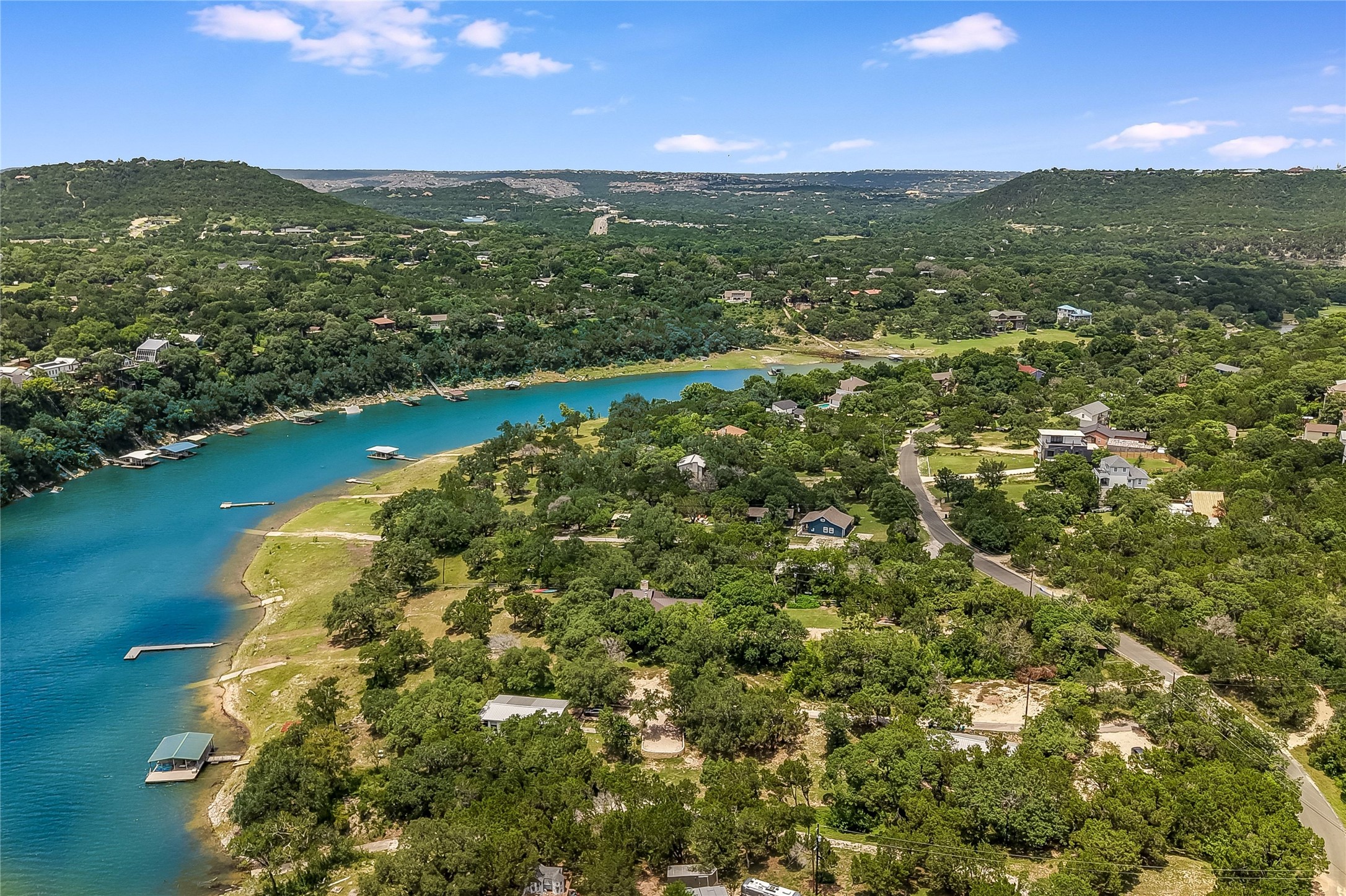 11104 Beach Road Leander, TX 78641 - Photo 15 of 15 A tranquil waterfront setting with private boat docks nestled among verdant hills.