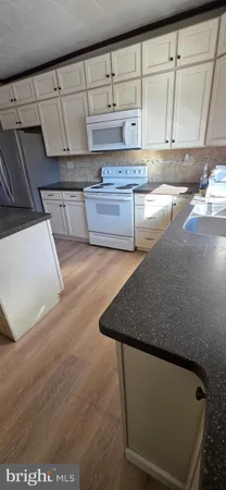 a kitchen with granite countertop a sink and a stove