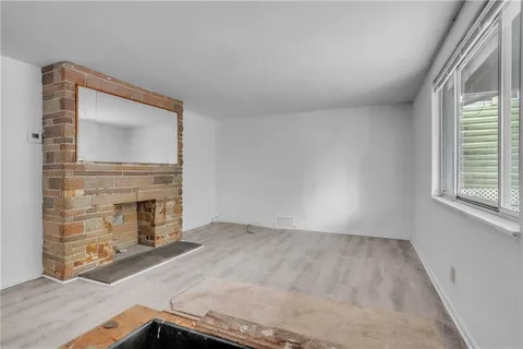 an empty room with windows fire place and an entrance