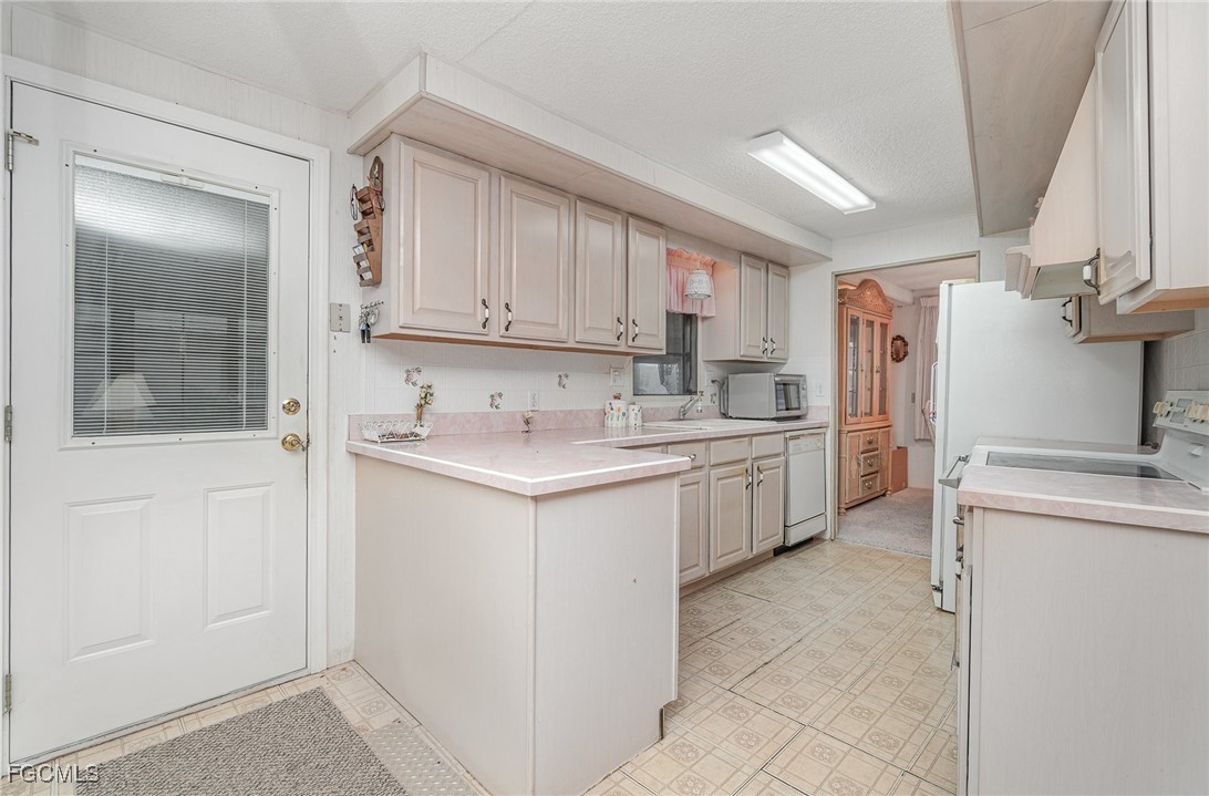 5 Aloe Alva, FL 33920 - Photo 6 of 37 a kitchen with white cabinets and white appliances