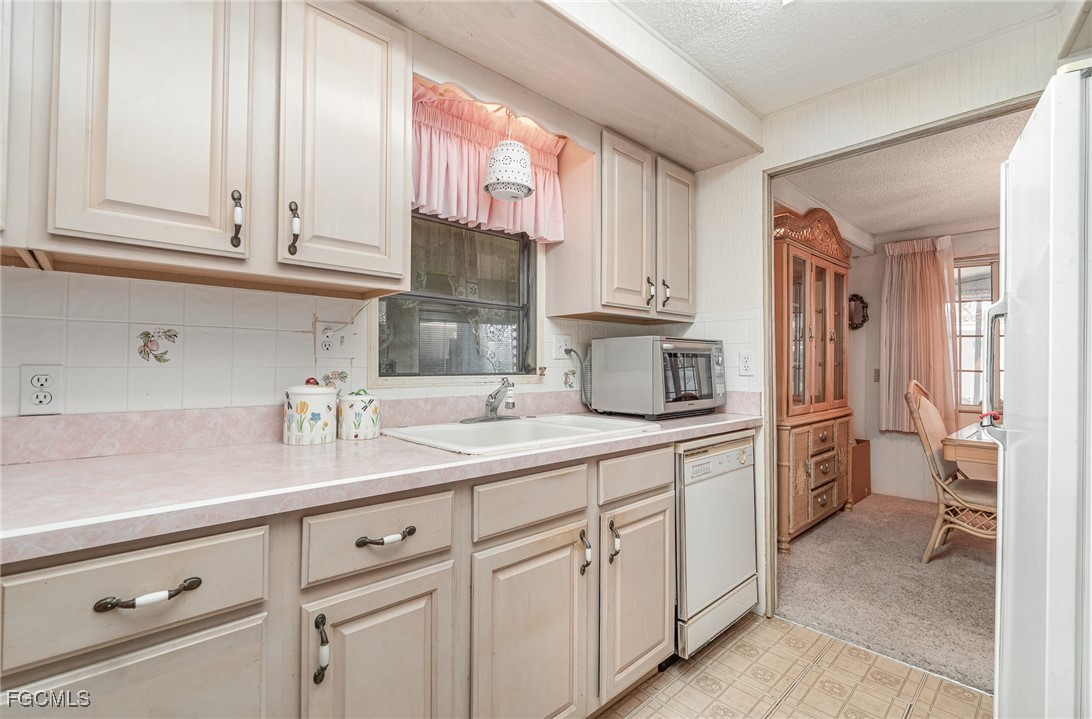 5 Aloe Alva, FL 33920 - Photo 7 of 37 a kitchen with white cabinets and white appliances