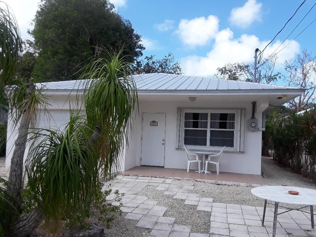 14 Jewfish Avenue Key Largo, FL 33037 - Photo 2 of 44 a house with a yard in front and a chair
