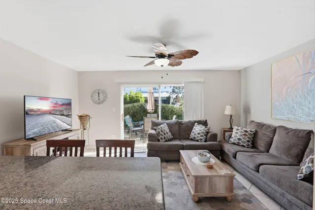 a kitchen with granite countertop a dining table chairs and a refrigerator