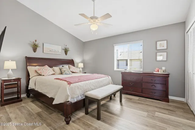 a bedroom with a bed and a table with wooden floor
