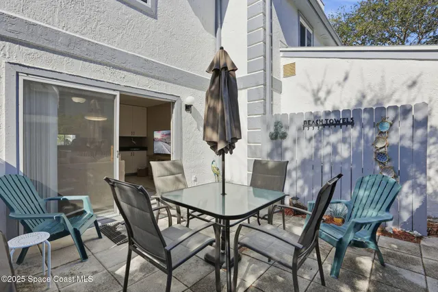 a view of a patio with table and chairs and potted plants