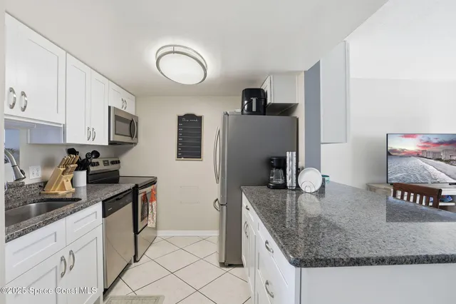 a kitchen with kitchen island granite countertop a stove top oven microwave and refrigerator