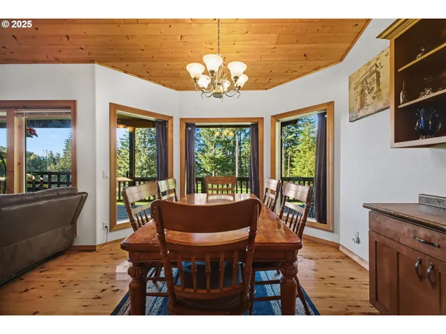 a dining room with furniture a chandelier and wooden floor