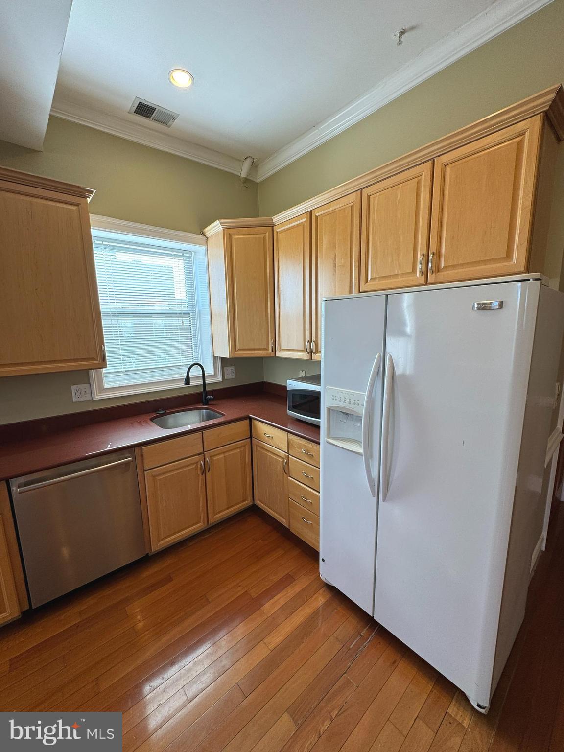 3445 14th Street Northwest, Unit 3 Washington, DC 20010 - Photo 3 of 15 a kitchen with granite countertop a refrigerator a sink and dishwasher wooden cabinets with wooden floor