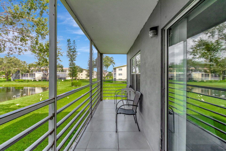 150 Dorset D, Unit 150 Boca Raton, FL 33434 - Photo 31 of 72 a view of a two chairs in the balcony next to a yard
