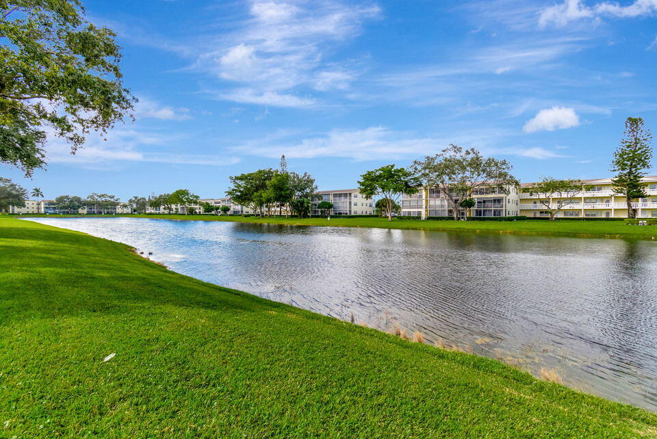 150 Dorset D, Unit 150 Boca Raton, FL 33434 - Photo 38 of 72 a view of a lake with houses in the background