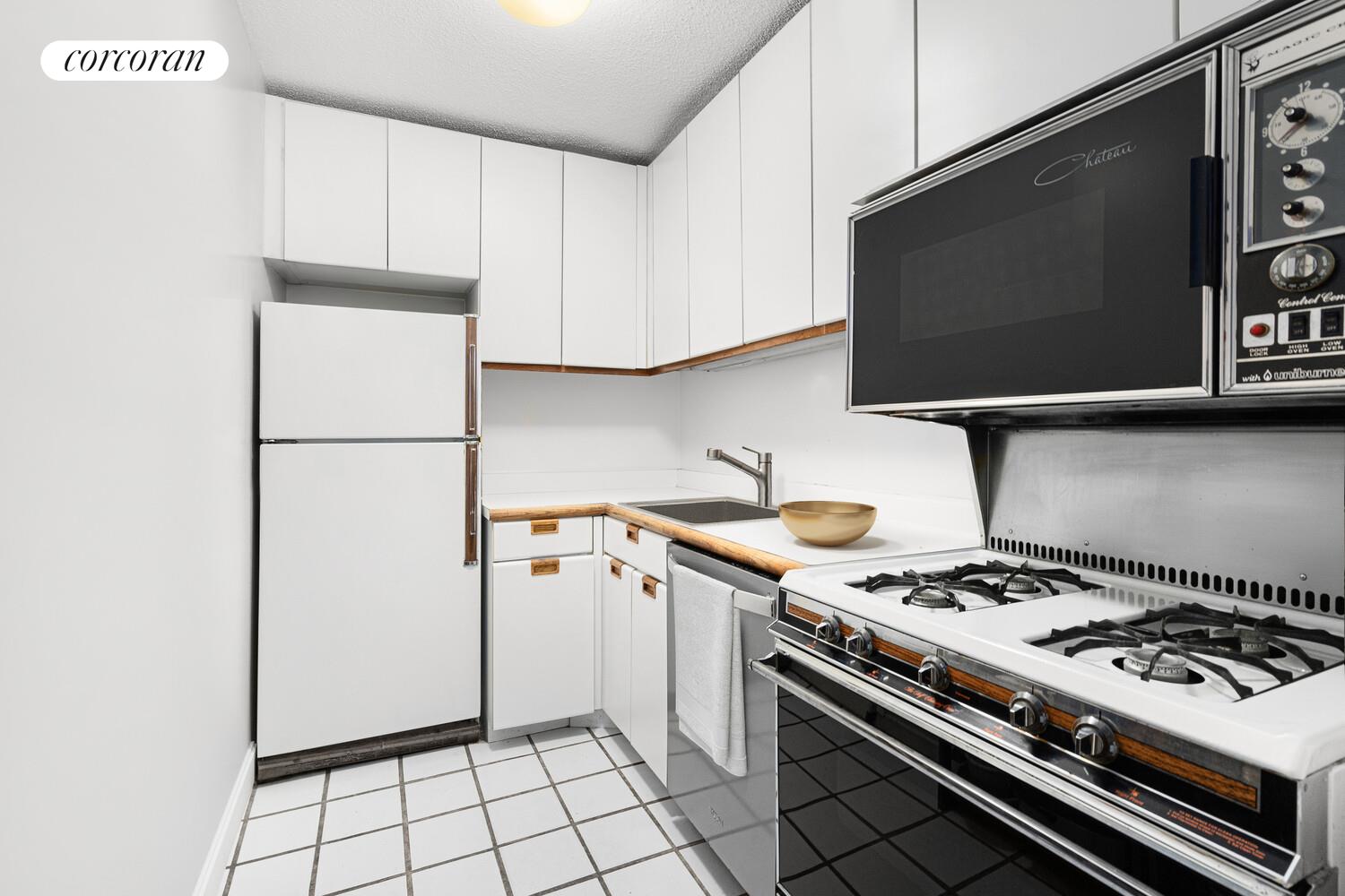 45 West 67th Street, Unit 8E Manhattan, NY 10023 - Photo 3 of 6 a kitchen with a stove and a microwave