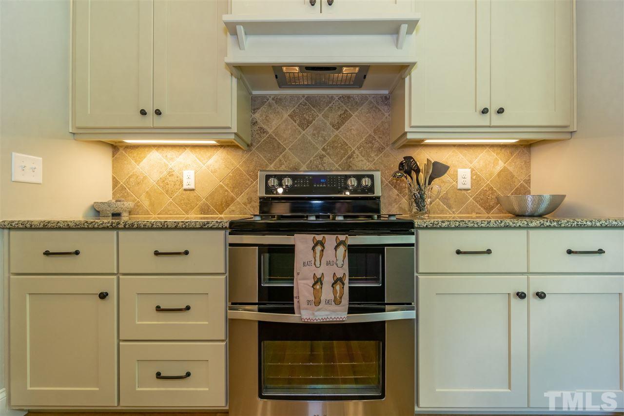 6112 Spring Branch Circle Raleigh, NC 27603 - Photo 16 of 30 a kitchen with white cabinets and a stove with wooden floor