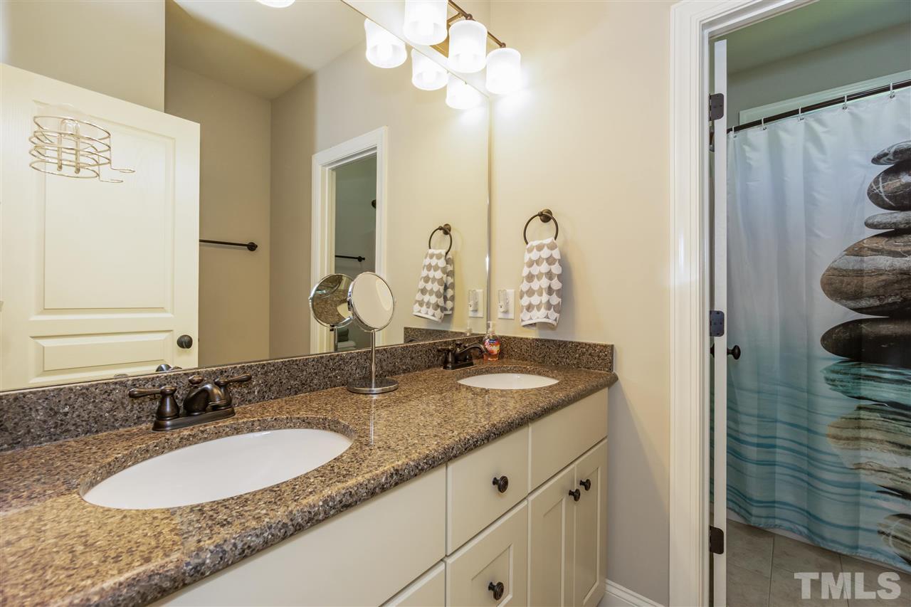 6112 Spring Branch Circle Raleigh, NC 27603 - Photo 27 of 30 a bathroom with a granite countertop sink and a mirror