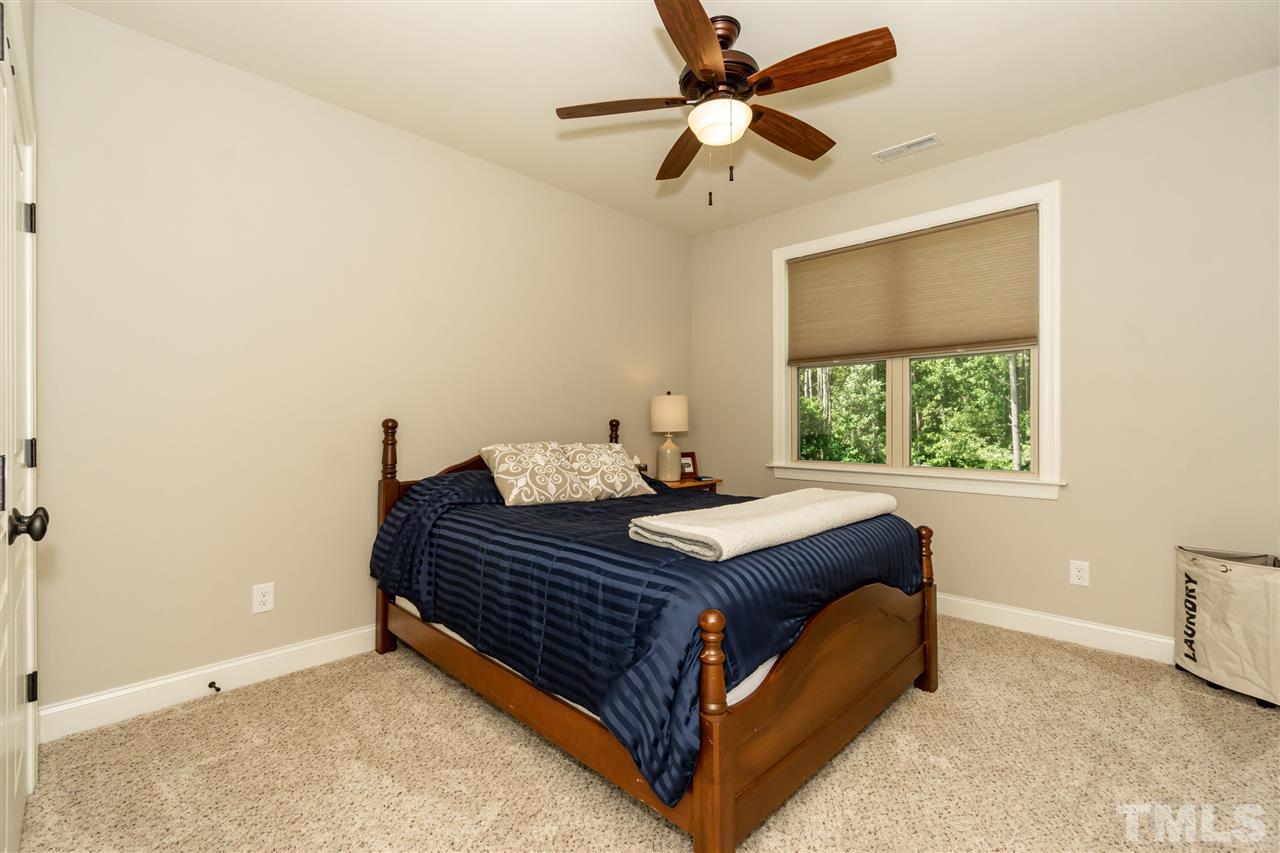 6112 Spring Branch Circle Raleigh, NC 27603 - Photo 28 of 30 a bedroom with a bed chandelier and a window