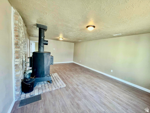 255 West Main Street Mount Pleasant, UT 84647 - Photo 13 of 35 Interior room featuring a wood-burning stove with brick hearth and surround