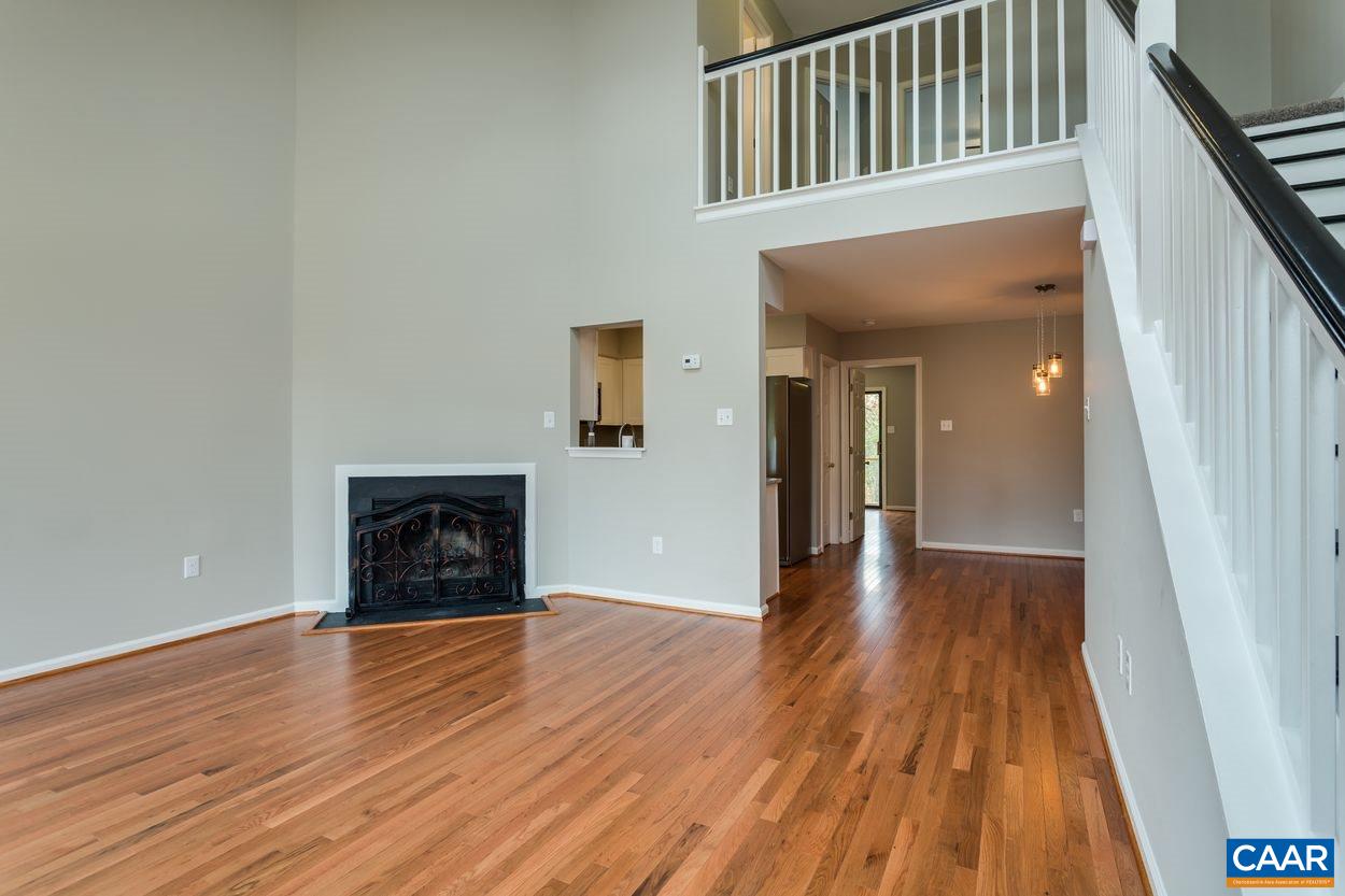1006 Ridgeley Court Charlottesville, VA 22901 - Photo 2 of 25 a view of an empty room with wooden floor and a fireplace