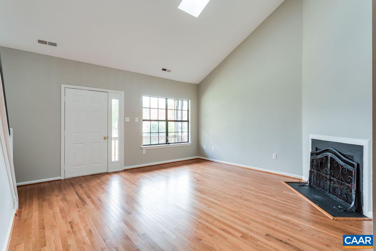1006 Ridgeley Court Charlottesville, VA 22901 - Photo 3 of 25 a view of an empty room with wooden floor fireplace and a window