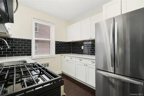 a kitchen with white cabinets and a stove top oven