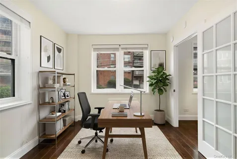 a view of a workspace with furniture and a window