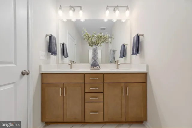 a bathroom with a double vanity sink and a mirror