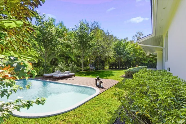 a view of a swimming pool with a yard and plants