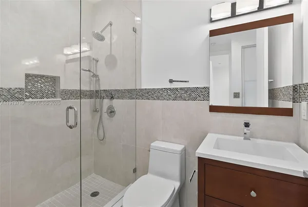 a bathroom with a sink a toilet and shower