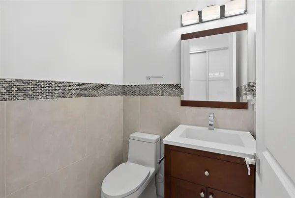 a bathroom with a sink a toilet and mirror
