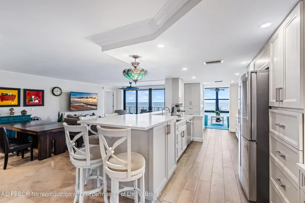 a kitchen with stainless steel appliances kitchen island granite countertop furniture and a refrigerator