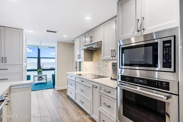 a kitchen with stainless steel appliances a stove microwave and sink