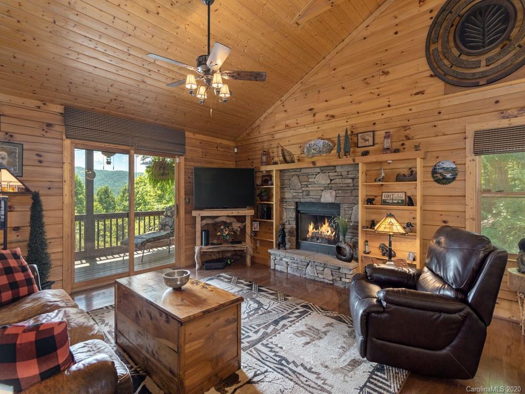 475 Indian Ridge Trail Hendersonville, NC 28739 - Photo 3 of 34 a living room with furniture a fireplace and a floor to ceiling window