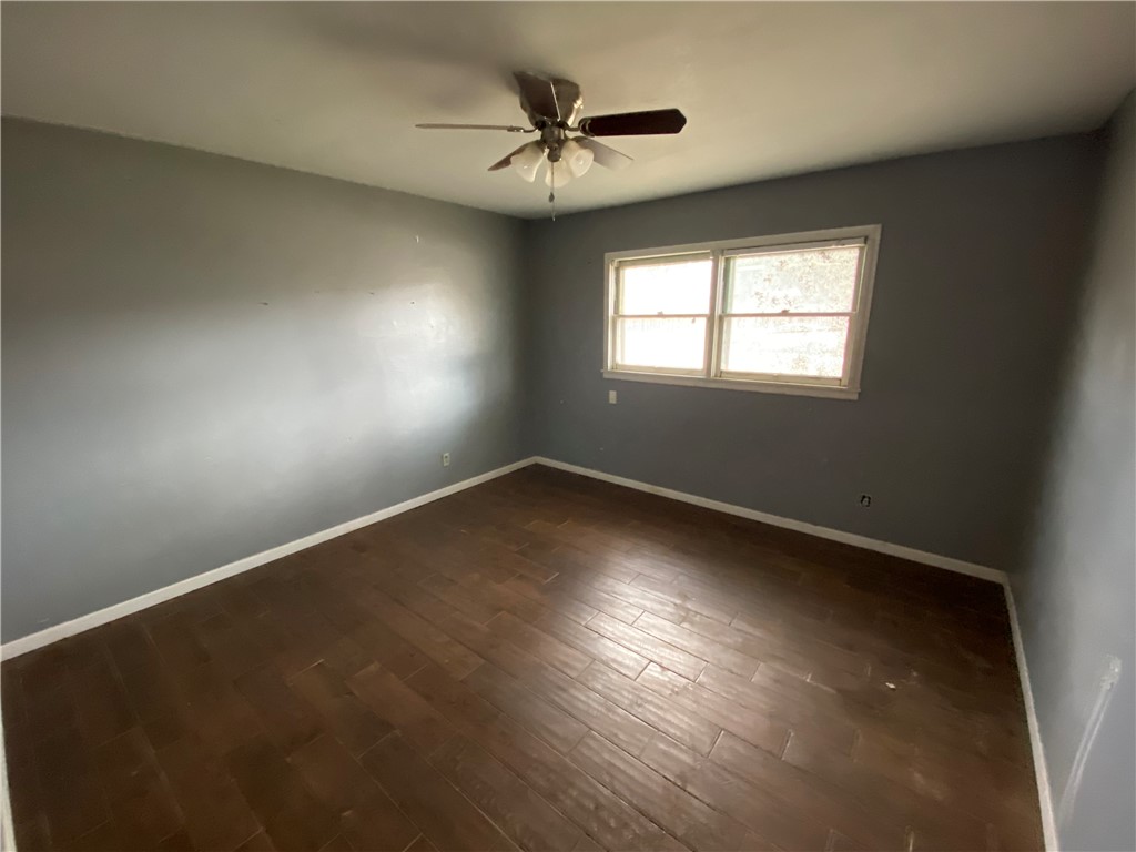 1211 Highland Avenue Alice, TX 78332 - Photo 11 of 28 an empty room with wooden floor and windows