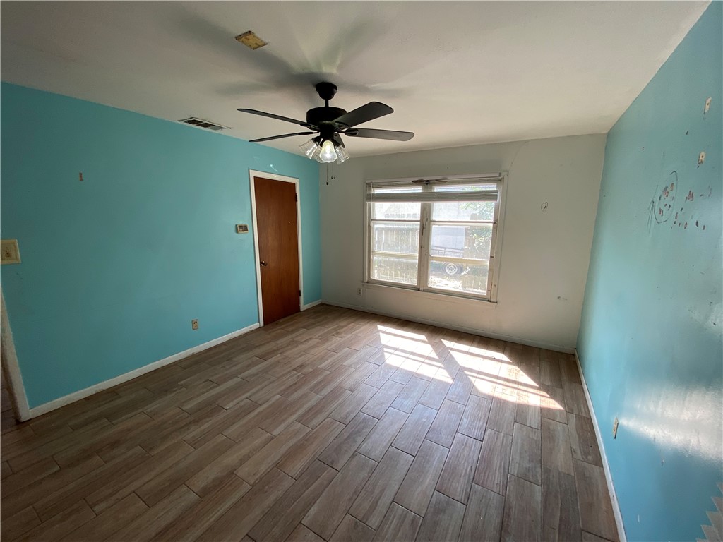1211 Highland Avenue Alice, TX 78332 - Photo 17 of 28 a view of empty room with wooden floor and fan