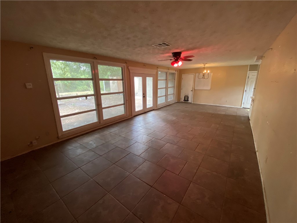 1211 Highland Avenue Alice, TX 78332 - Photo 8 of 28 an empty room with chandelier fan and windows