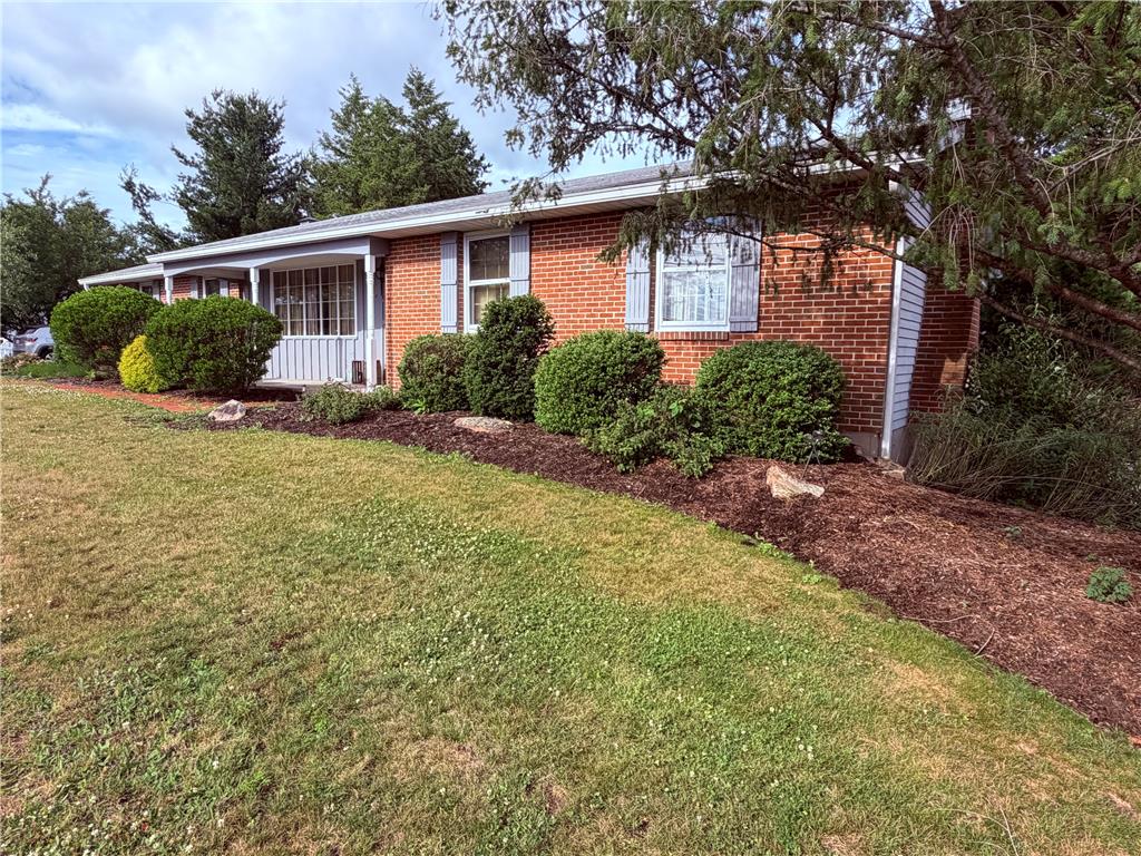 5963 Valley Road Slatington, PA 18080 - Photo 3 of 20 A classic brick facade with vibrant landscaping awaits in this charming residence.