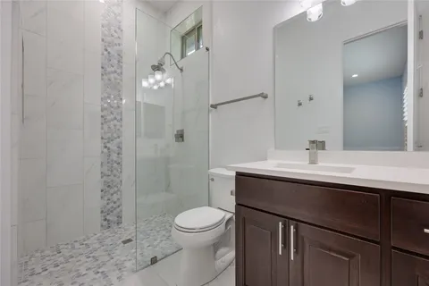 a bathroom with a sink a toilet and shower