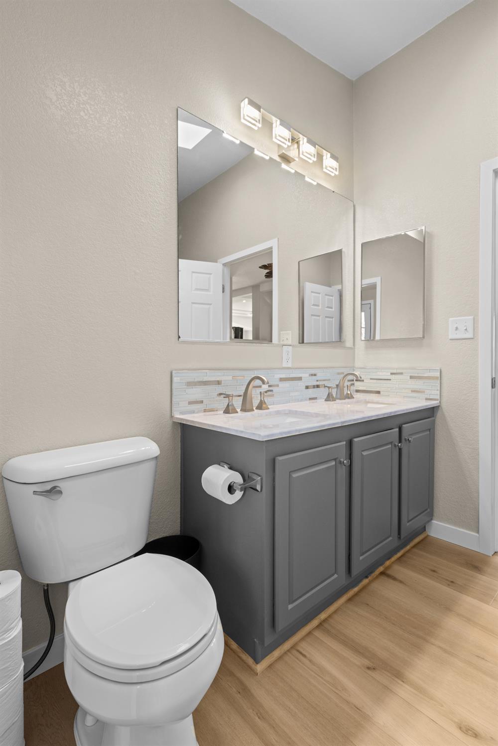 10665 Harris Road Auburn, CA 95603 - Photo 20 of 34 a bathroom with a granite countertop toilet a sink and a mirror