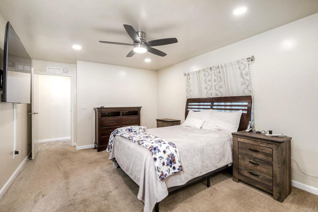 18218 Paradise Mountain Road Valley Center, CA 92082 - Photo 24 of 34 a bedroom with a bed and a chandelier