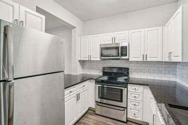 a kitchen with stainless steel appliances granite countertop a refrigerator and a sink
