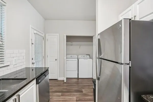 a kitchen with stainless steel appliances granite countertop a sink a stove and a refrigerator