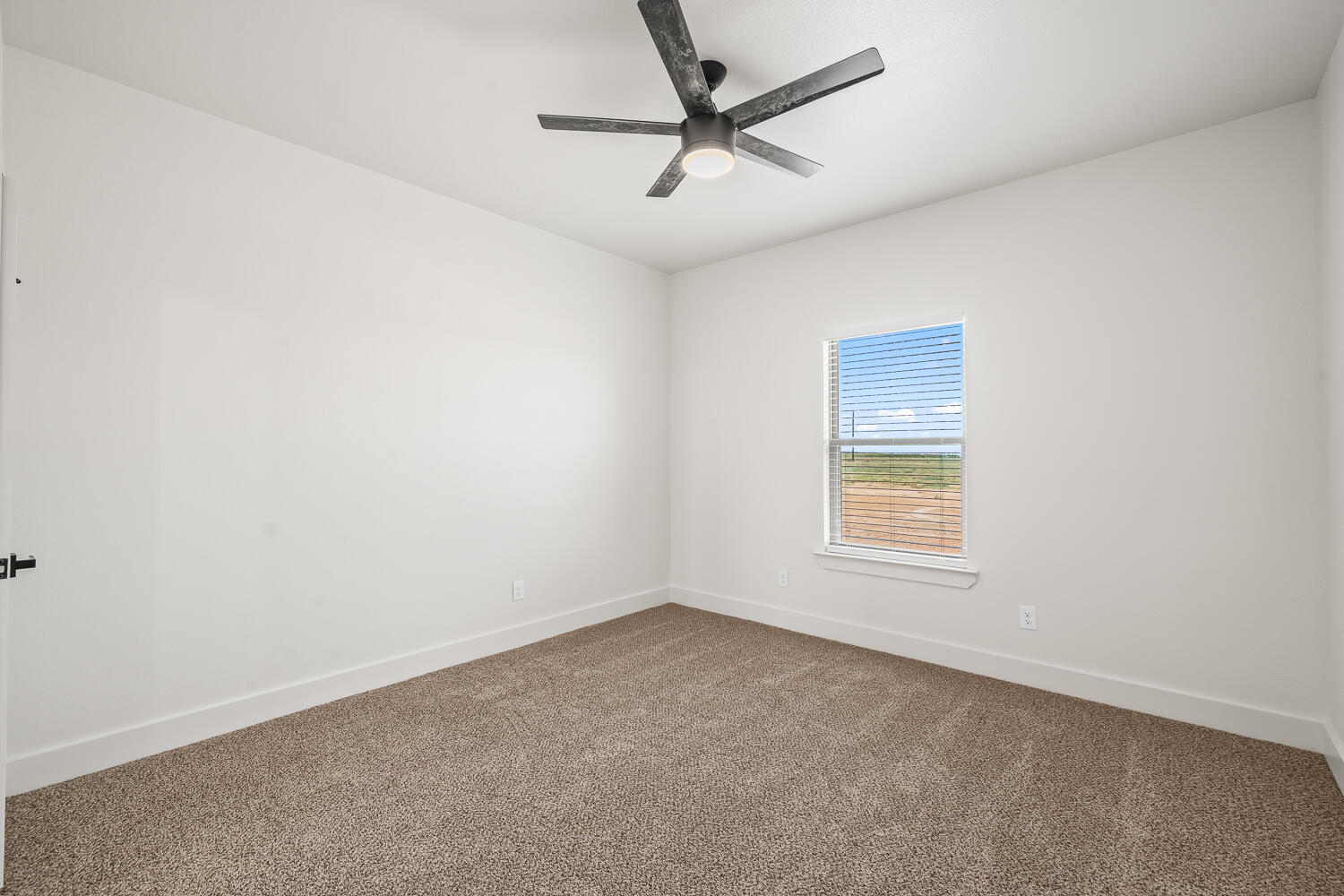 7205 East F M 41 Slaton, TX 79364 - Photo 19 of 47 an empty room with a window and a fan