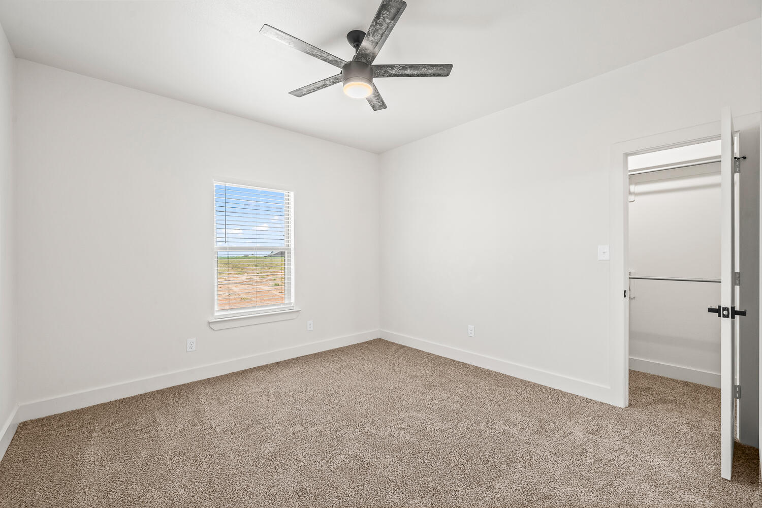 7205 East F M 41 Slaton, TX 79364 - Photo 25 of 47 an empty room with a window and a fan