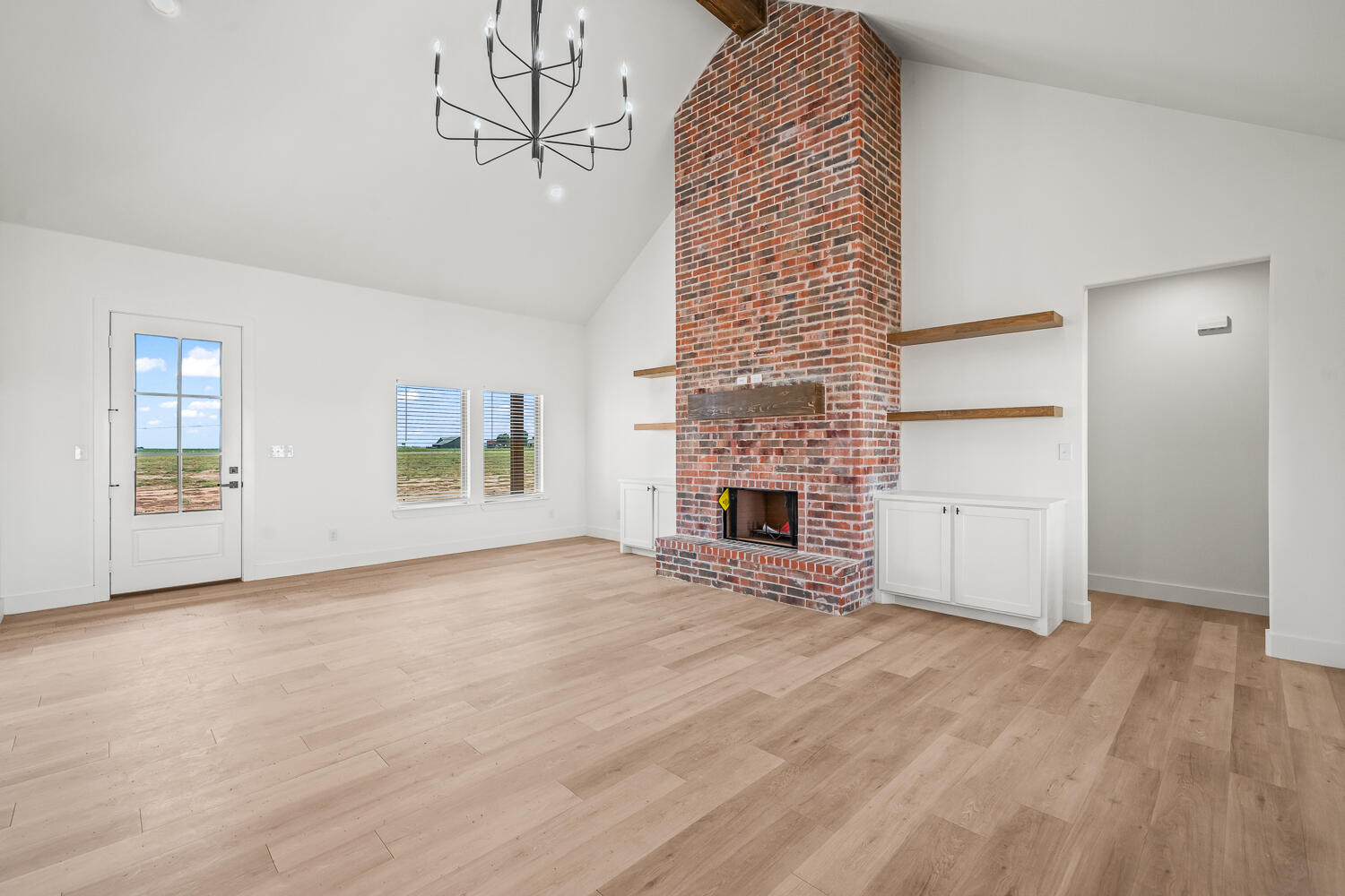 7205 East F M 41 Slaton, TX 79364 - Photo 38 of 47 a view of an empty room with chandelier and fireplace