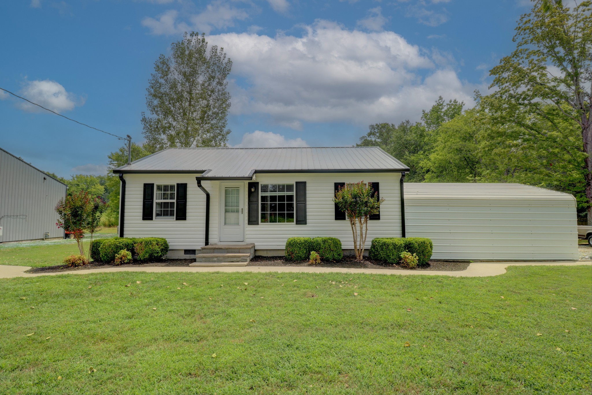 4437 Hickerson Road Manchester, TN 37355 - Photo 27 of 27 a front view of a house with a garden and plants