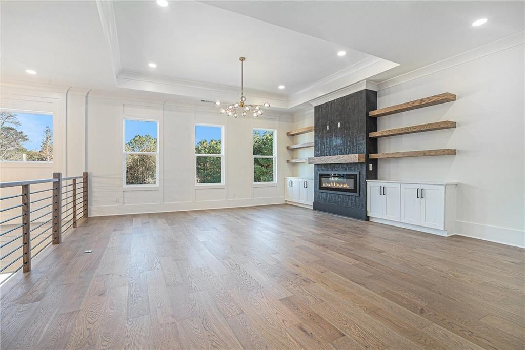 5745 Union Church Road Braselton, GA 30517 - Photo 12 of 16 an empty room with wooden floor fireplace and windows