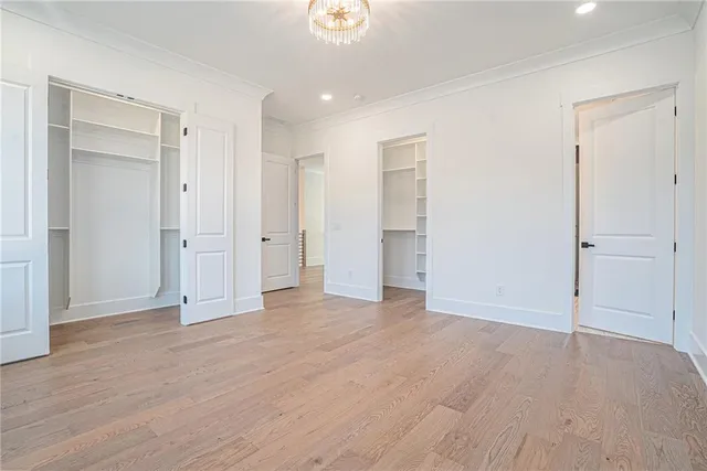 an empty room with wooden floor & closet area