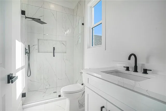 a bathroom with a sink a toilet and shower