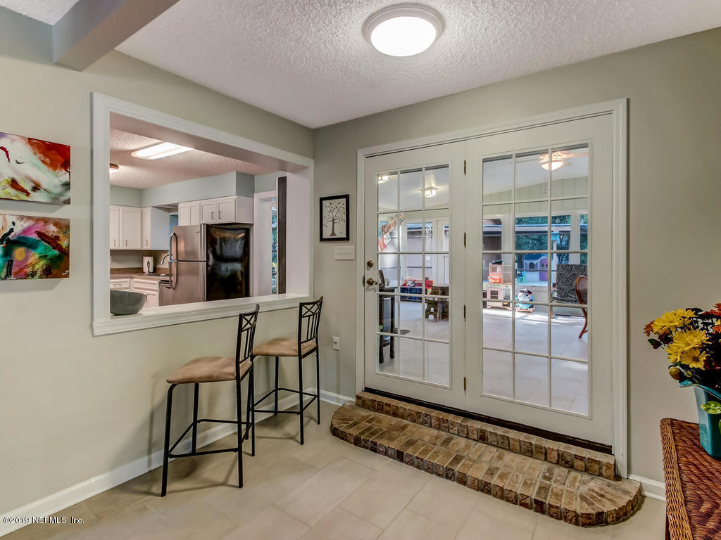 4629 Homestead Road Jacksonville, FL 32210 - Photo 12 of 27 a view of a hallway with dining area and chandelier