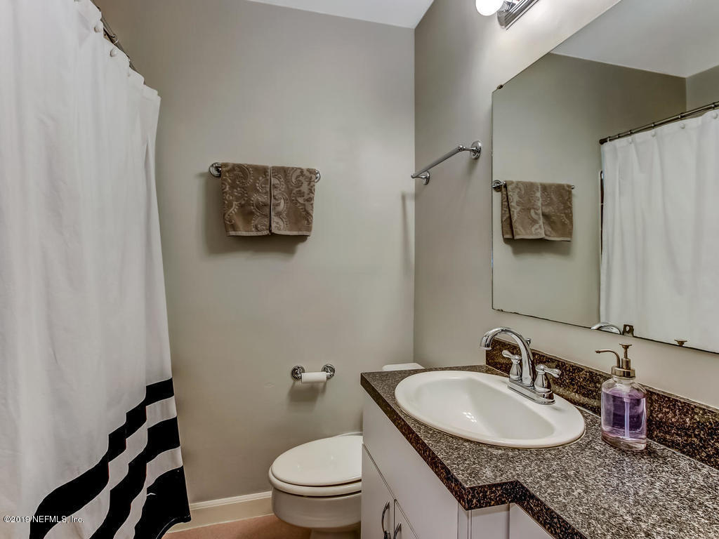 4629 Homestead Road Jacksonville, FL 32210 - Photo 20 of 27 a bathroom with a granite countertop sink a mirror and a toilet