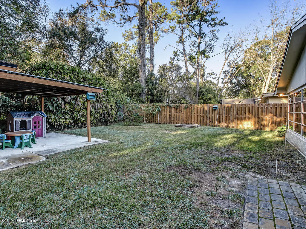 4629 Homestead Road Jacksonville, FL 32210 - Photo 23 of 27 a view of a backyard with large trees and a barn